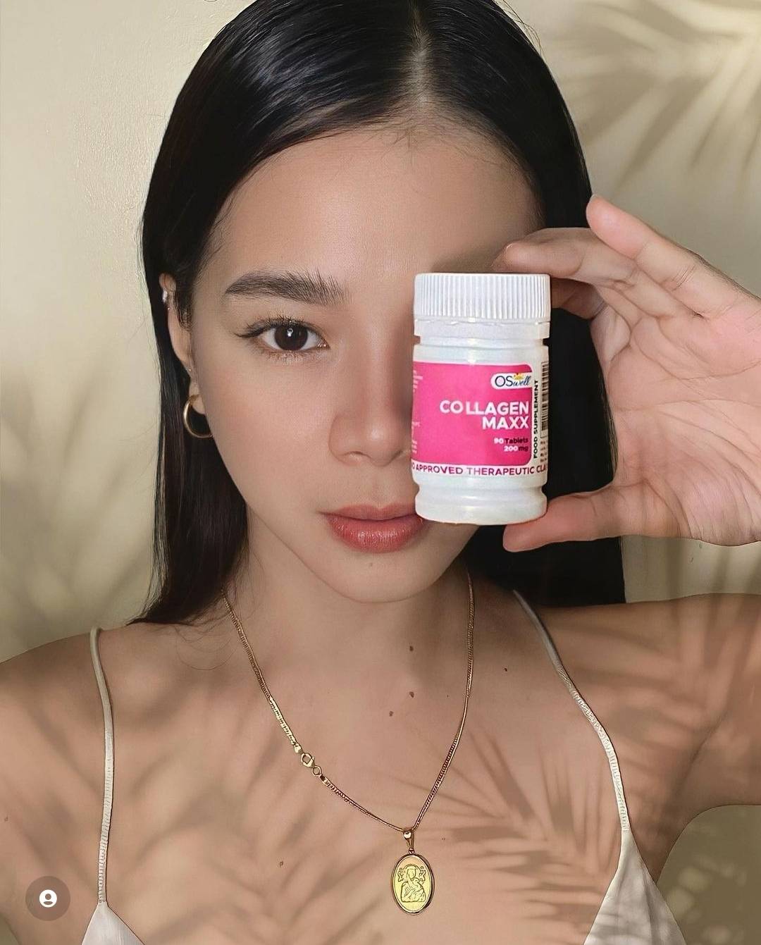 Model with radiant skin holding Gluta Maxx bottle