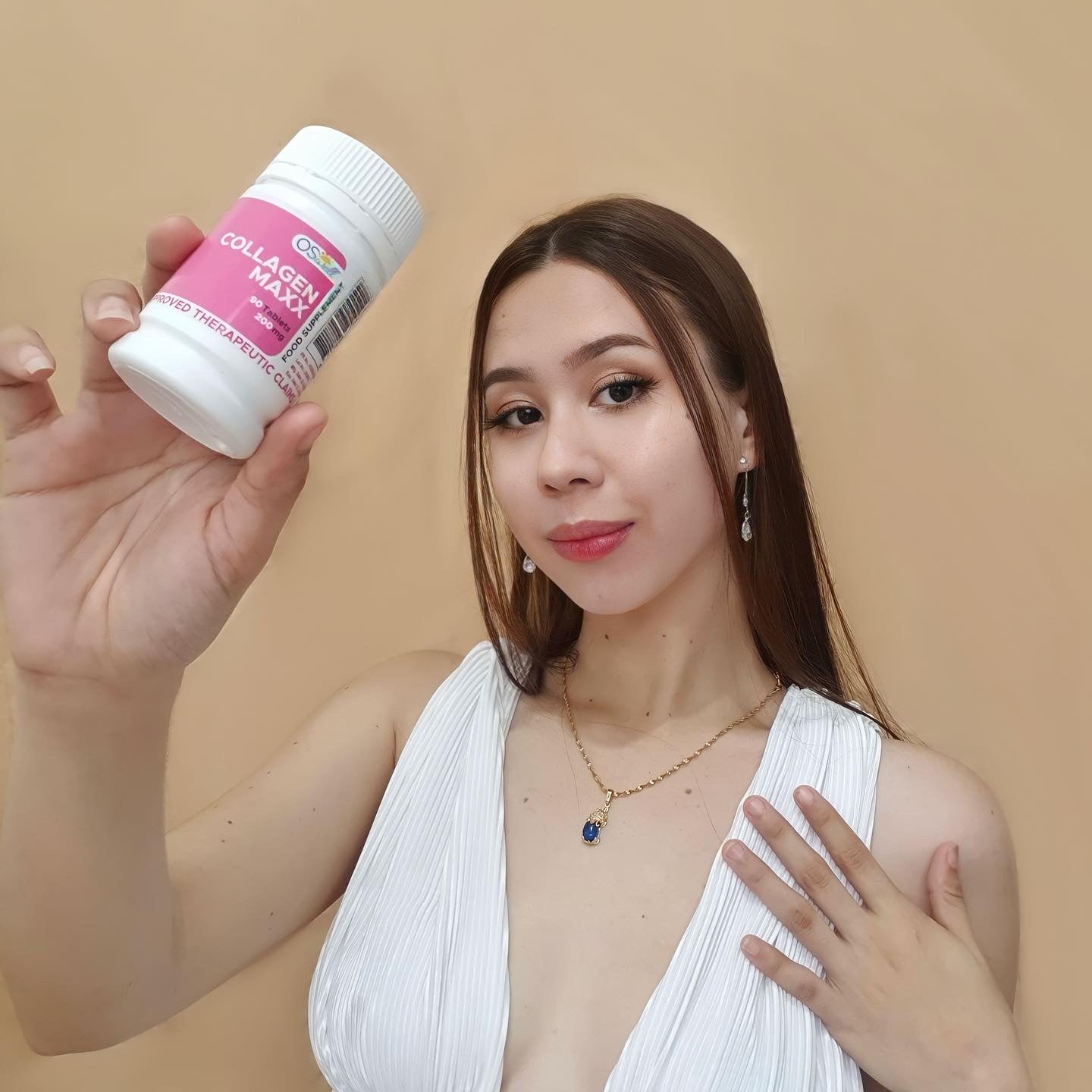 Model with radiant skin holding Gluta Maxx bottle