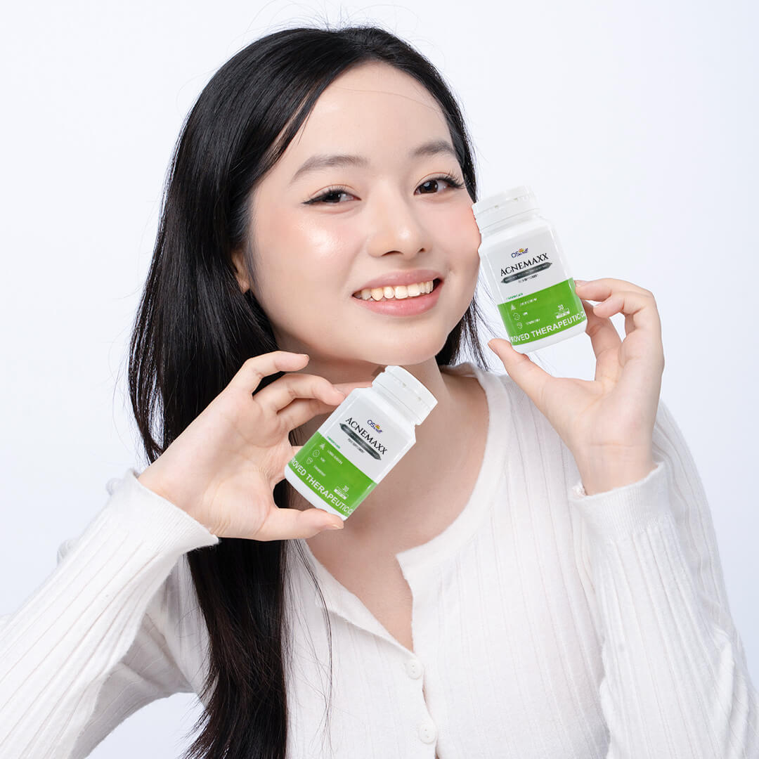 Smiling woman holding OSwell Acnemaxx – anti-acne supplement for clearer skin