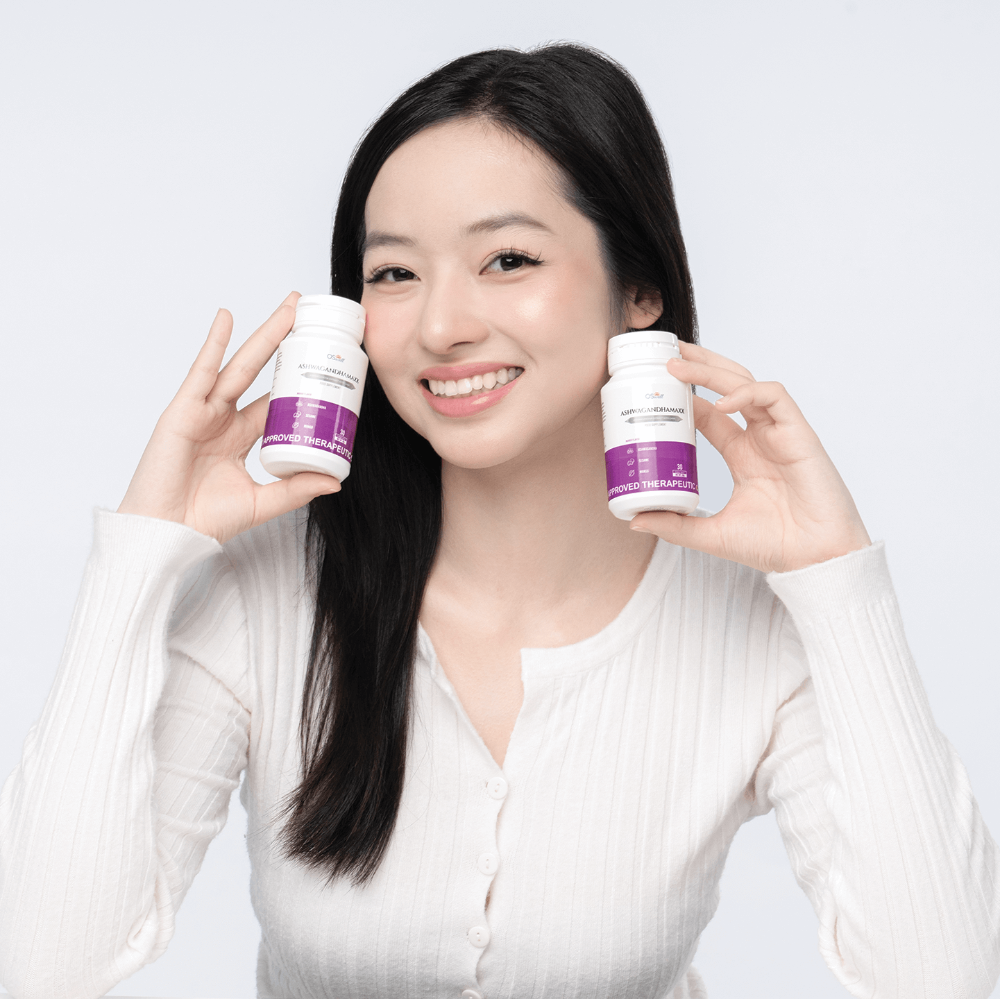 Happy woman holding OSwell AshwagandhaMaxx bottles – natural stress and anxiety relief